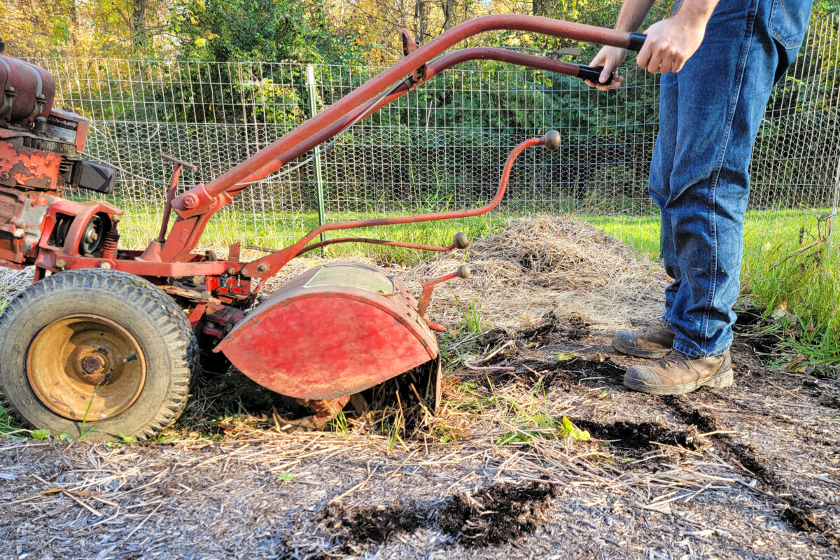 Man's lower torso, operating a rototiller